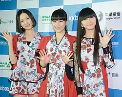 Three women on stage at a music concert
