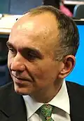 A top-down view of a man in a suit looking to the left of the screen