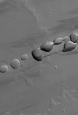 Mars Global Surveyor image of pit crater chain northwest of Tharsis Tholus.
