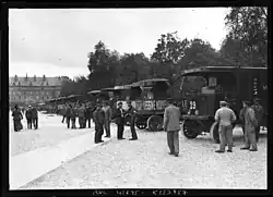 A line of trucks carrying advertising banners.