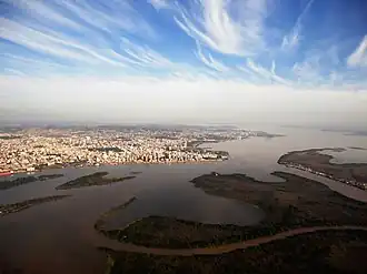 A city by a large river with islands in the foreground.