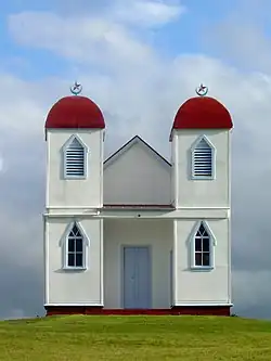 Simple white building with two red domed towers