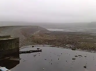 Image of an almost dry reservoir in heavy mist