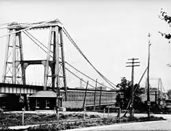 Towers, made of steel beams, hold up the cables that suspend a bridge.