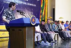 Rodrigo Duterte speaks on a podium at an assembly