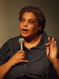 Gay speaking into a microphone