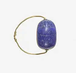 Ancient Egyptian scarab finger ring; 1850–1750&nbsp;BC; lapis lazuli scarab set in gold plate and on a gold wire ring lapis-lazuli; diameter: 2.5&nbsp;cm (0.98&nbsp;in), the scarab: 1.8&nbsp;cm (0.71&nbsp;in); Metropolitan Museum of Art