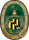 A roughly oval seal with heraldic elements surrounded by a tan border