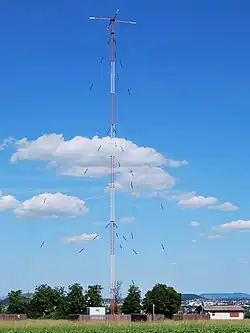 Mast radiator antenna of medium wave radio station. The sideways radial arms on the top are a "capacitance hat".