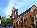 St Dionis, Parsons Green, London, 1884–85 by Ewan Christian, tower completed 1896, showing the north aisle and north-east tower, the church is in the Perpendicular Gothic style - less typical of Christian[64]