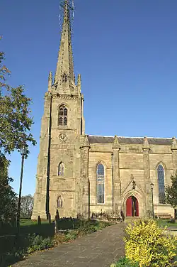 A Gothic-style steeple with part of the body of the church to the right