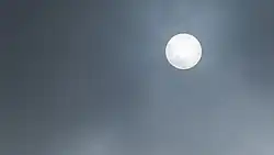 A photograph of the sun with a layer of fog visible in front of it.