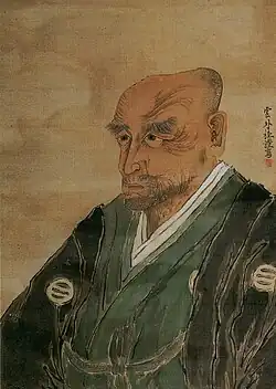 Portrait of an elderly man wearing a green kimono and black haori