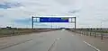 Terminal East gantry sign at Denver International Airport with an empty freeway during the pandemic.