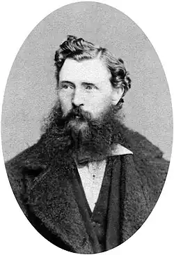 A dark-haired man with a scruffy beard