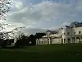 The small mansion with the large mansion in the background to the left