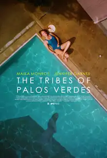 An overhead view of a woman in a blue bathing suit lying at the edge of a swimming pool. The water of the pool shows the shadowy reflection of another woman.