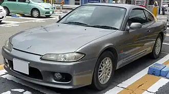 Front-three-quarter view of a two-door car with door mirrors