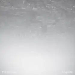 A high-up and monochrome view of a foggy urban city taken upside down, with the text "TIM HECKER" and "NO HIGHS" in the bottom corners.