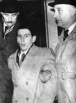 Evans being escorted by two taller men on either side of him