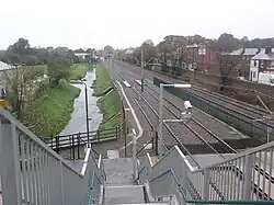 Tram stop, rail lines and River Leen seen from bridge looking north