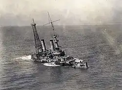 A sinking stripped battleship seen from a birds eyes view