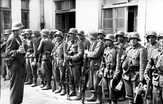 A group of uniformed soldiers in front of a building