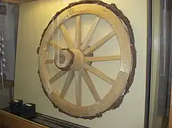 Iron wheel on modern wooden spokes in a display case