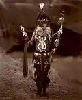 Navajo man in ceremonial dress with mask and body paint, c. 1904
