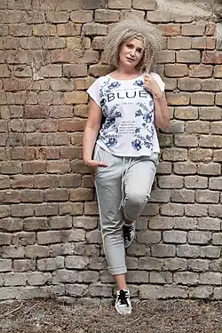Zuzana Vačková leaning against a wall, facing camera