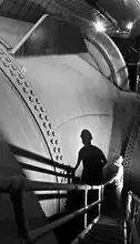 A worker stands by the 30&nbsp;ft (9.1&nbsp;m) diameter Nevada penstock before its junction with another penstock that delivers water to a turbine.